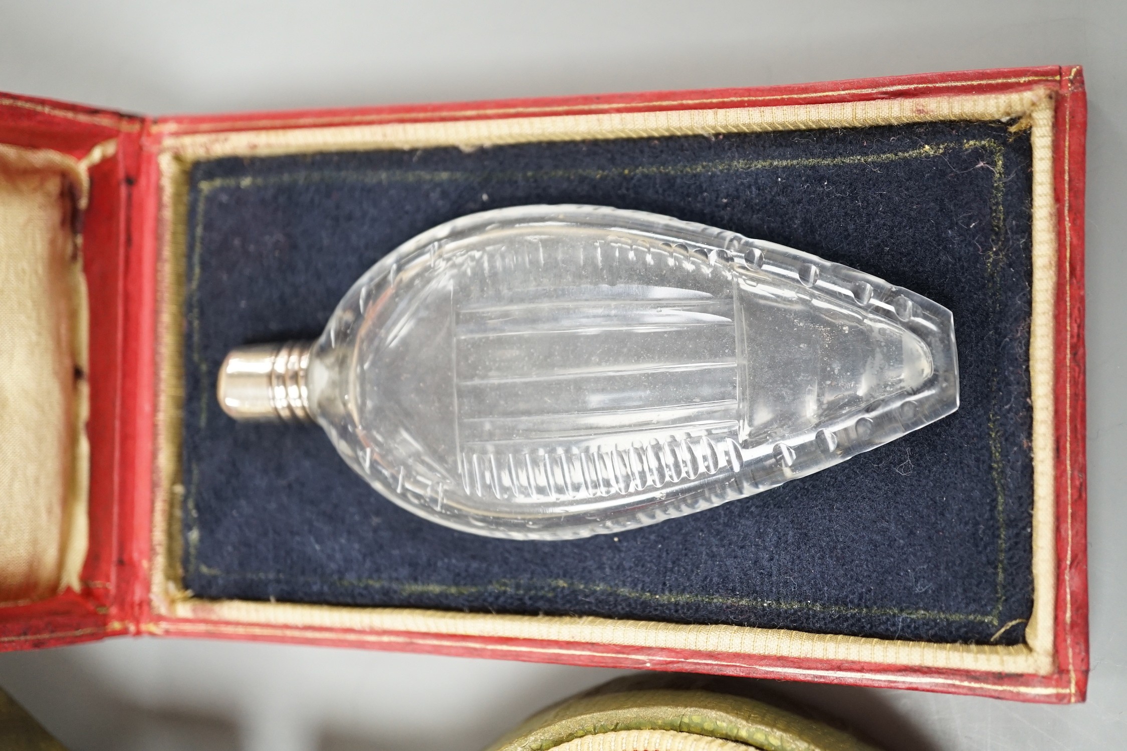 A cased Sampson Mordan white metal mounted ruby glass scent bottle, 7cm, one other mounted glass scent bottle and a mother of pearl mounted lipstick holder.